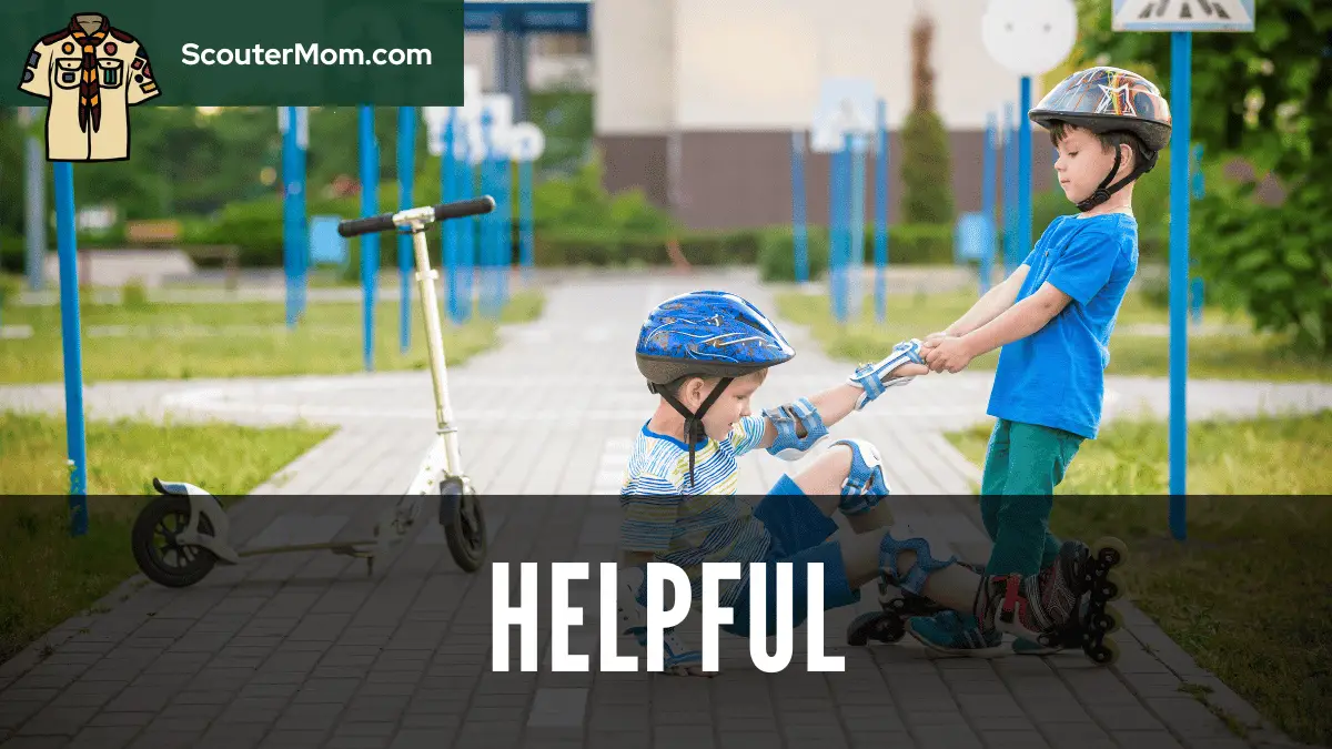 Two boys, one helping the other one who has fallen while roller skating, demonstrating that a Scout is helpful.