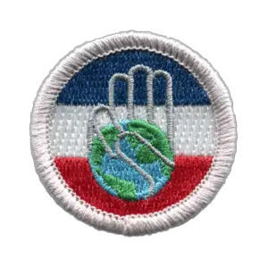 The Citizenship in Society merit badge emblem, a circular patch with a red, white and blue background. It has the outline of a hand making the Scout sign and the palm of the hand is the earth.